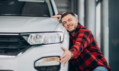 young man choosing a car in a car showroom